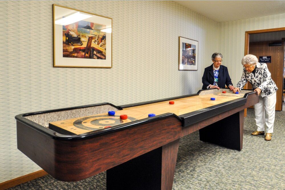 A person playing shuffleboard in an indoor setting.