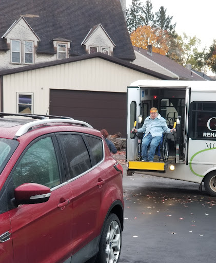 A transport vehicle assisting individuals, parked in front of a house.