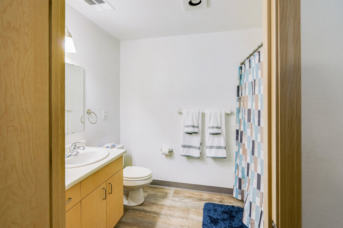 A clean and organized bathroom with a sink, toilet, and shower curtain.
