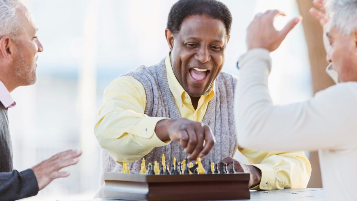 A person smiling while playing a game of chess.