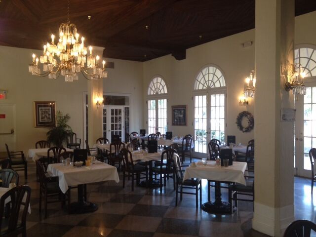 An elegant restaurant dining area with neatly arranged tables and a grand chandelier.