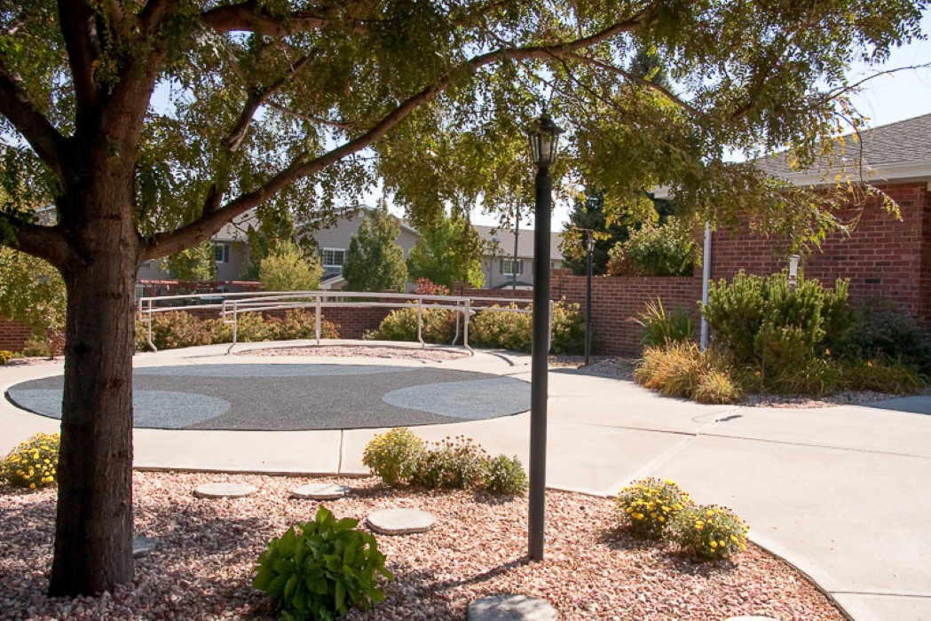 A peaceful park area with a pathway, surrounded by trees and plants.