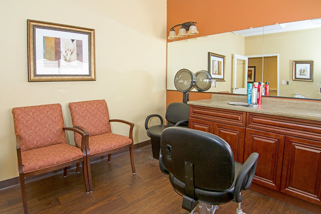 A cozy hair salon interior with styling chairs and a mirror.