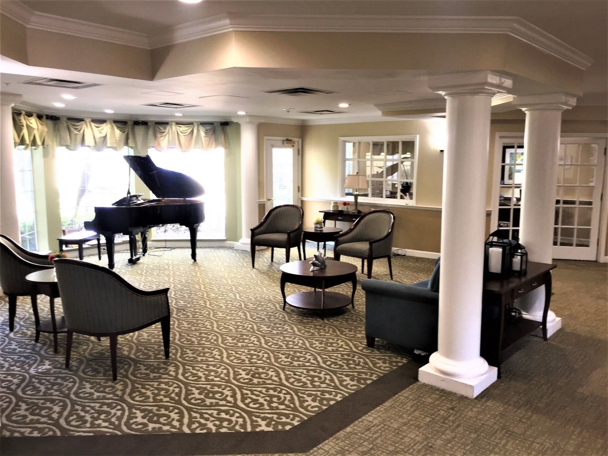 A sophisticated lounge with comfortable seating and a grand piano.