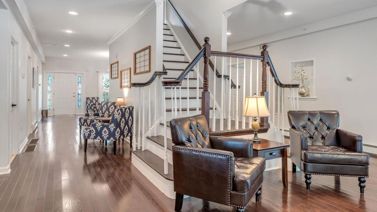 A cozy living space featuring a staircase, elegant chairs, and warm lighting.