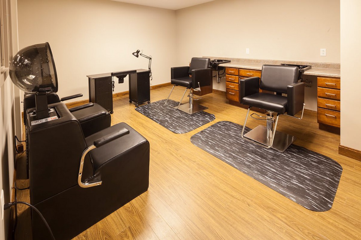 A cozy hair salon with stylish chairs, mirrors, and wooden flooring.
