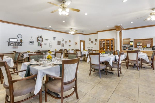 A well-lit restaurant dining area with neatly arranged tables and chairs.