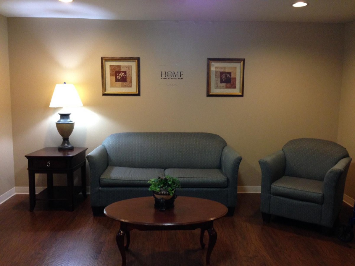 A cozy living room setup with a sofa, armchair, table, and decor.