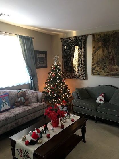 A cozy living room decorated for the holidays with a Christmas tree and festive decorations.