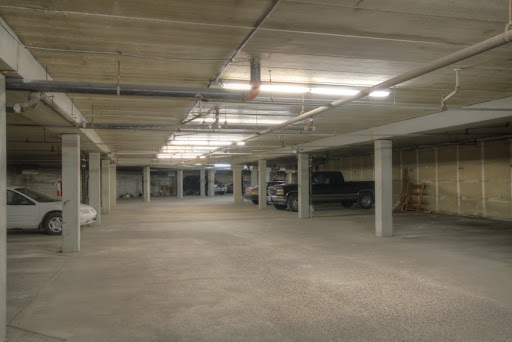 A spacious, well-lit indoor parking garage with several vehicles parked.