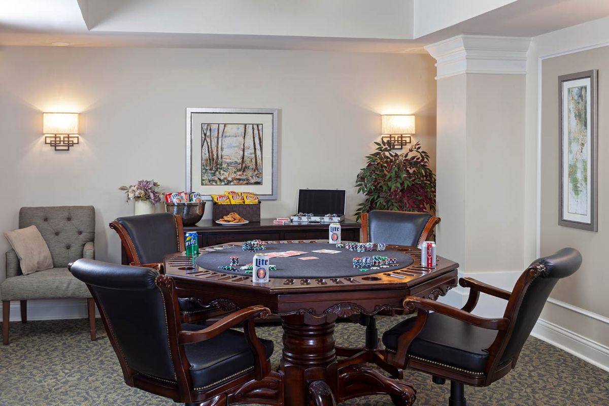 An indoor poker table setup with chairs, cards, drinks, and snacks.