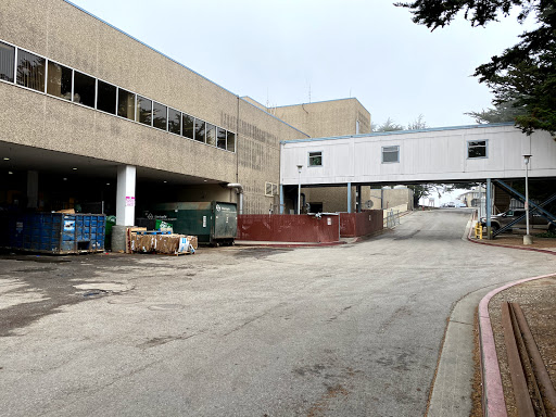 An industrial area featuring a concrete building and a connecting walkway.