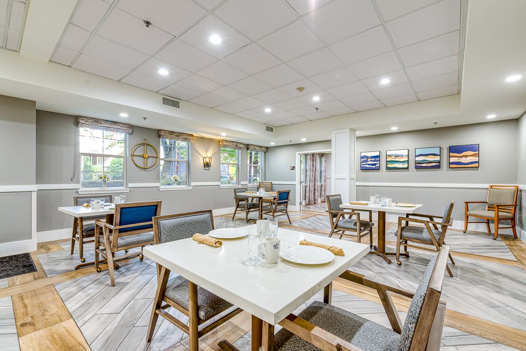 A modern and well-lit dining area with neatly arranged tables and chairs, featuring stylish interior decor.