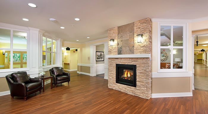 A modern living room with a cozy fireplace and stylish wood flooring.