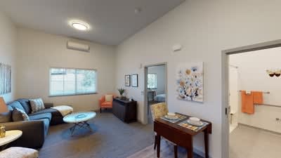A cozy and modern living room featuring minimalistic decor with a seating area and artwork on the walls.