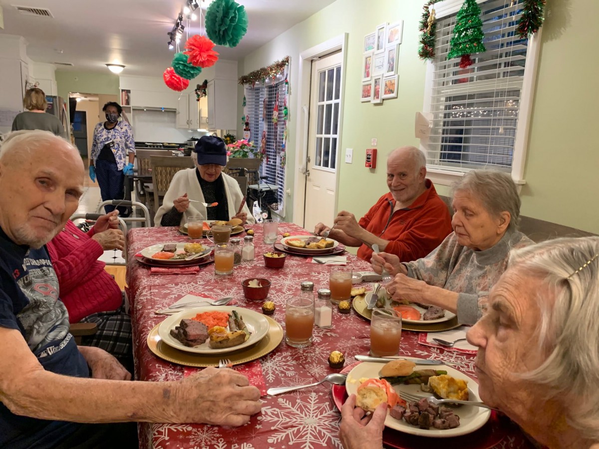 A family gathers around the table for a festive holiday dinner.
