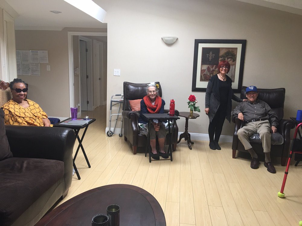 A group of people relaxing in a living room setting with comfortable seating and home decor.