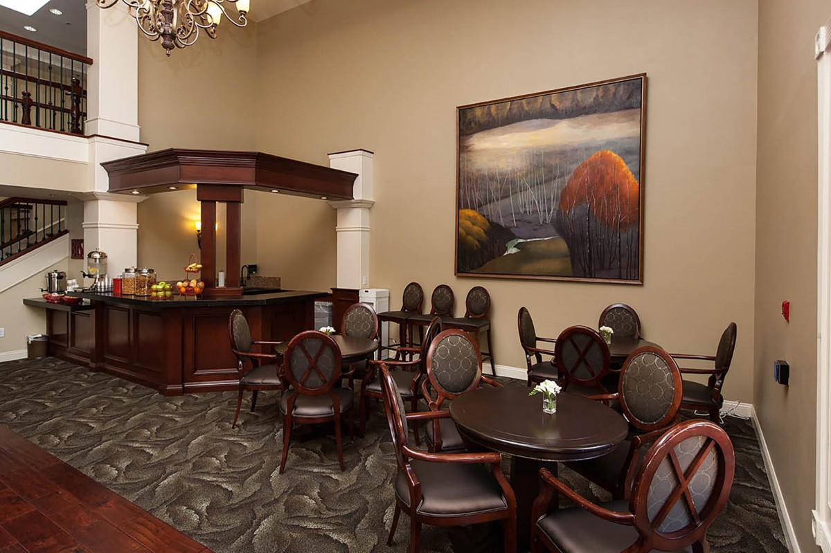 Elegant lounge area featuring artwork, a chandelier, and comfortable seating.