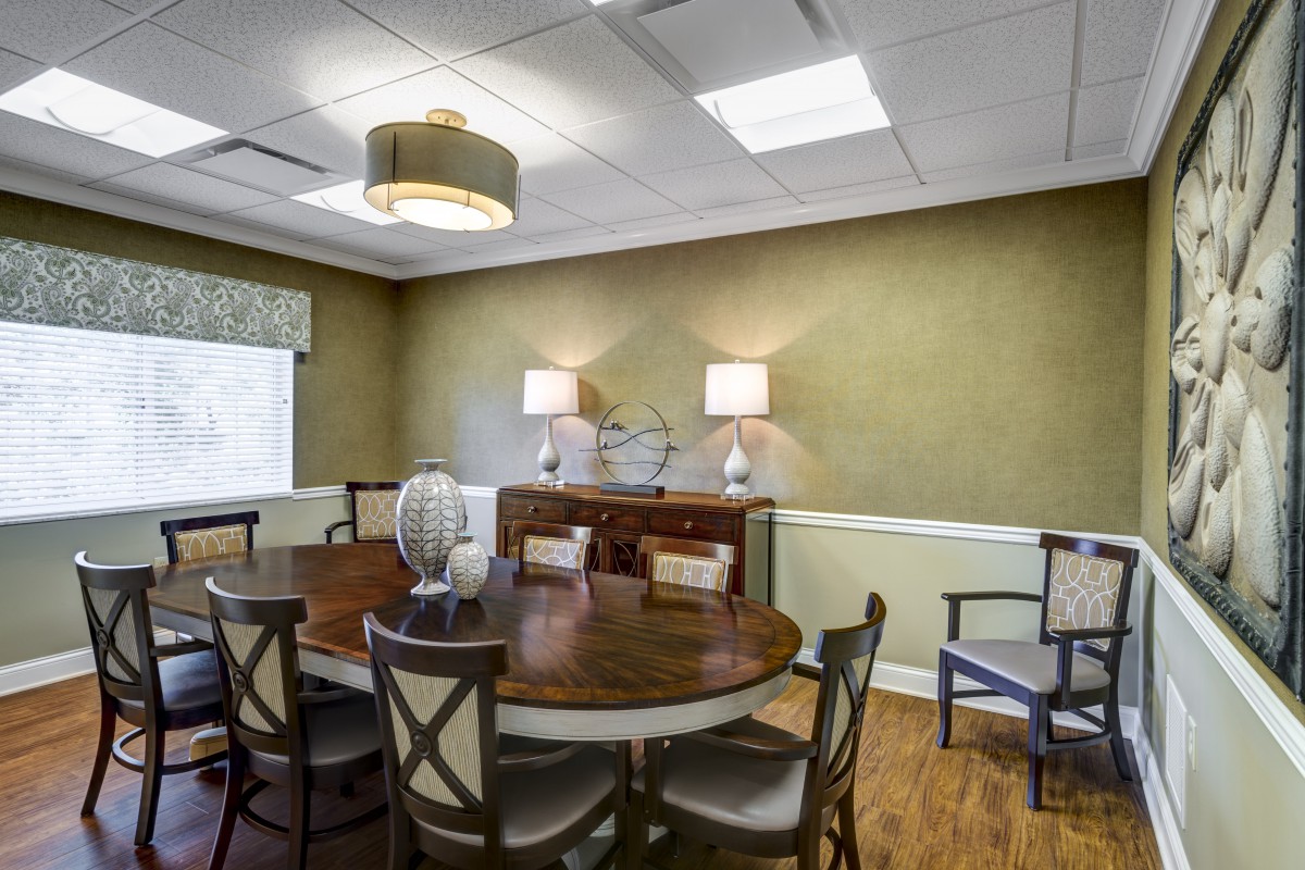 A cozy dining room with a round table and elegant decor.