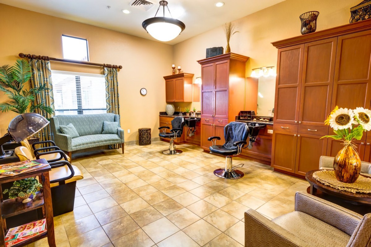 A well-lit salon interior featuring barber chairs, wooden cabinets, and comfortable seating.