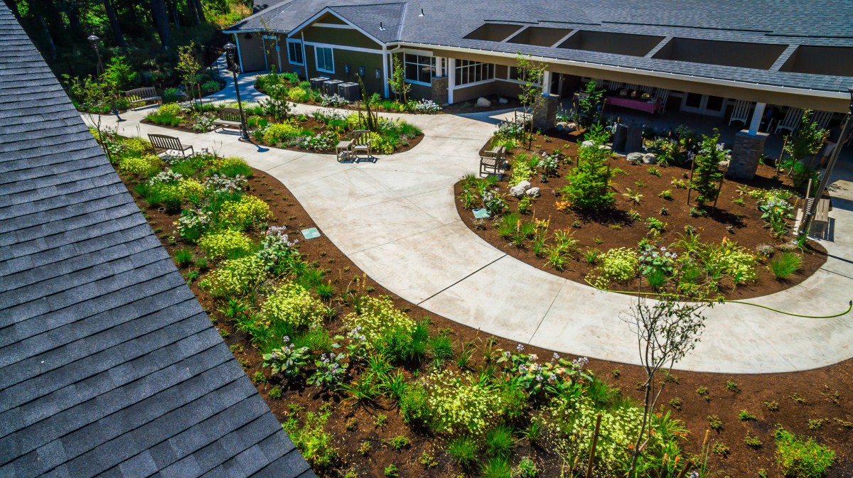 A beautifully landscaped garden with a winding pathway leading to a building entrance.