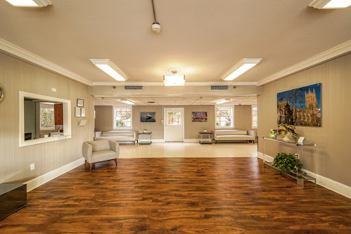 A spacious and well-lit interior room featuring comfortable furniture and wooden flooring.