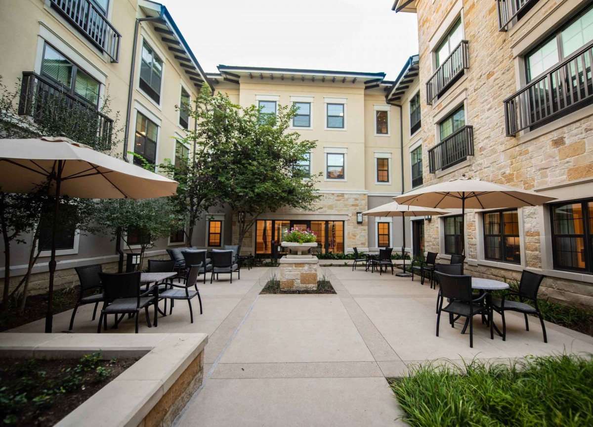A well-maintained courtyard with outdoor seating surrounded by a residential building.