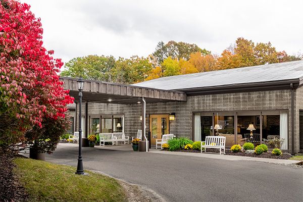 A modern building surrounded by autumn foliage and well-maintained landscaping.