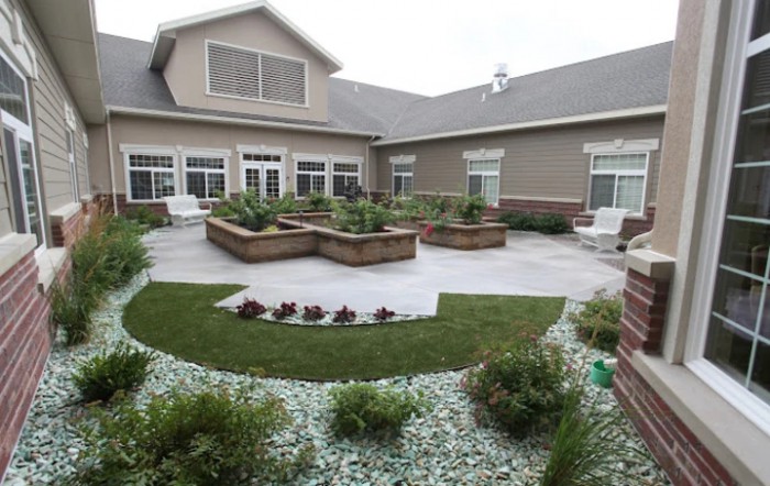A beautifully landscaped courtyard with raised garden beds and lush greenery.