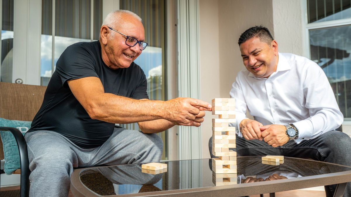 Two people enjoying a game of Jenga together indoors.