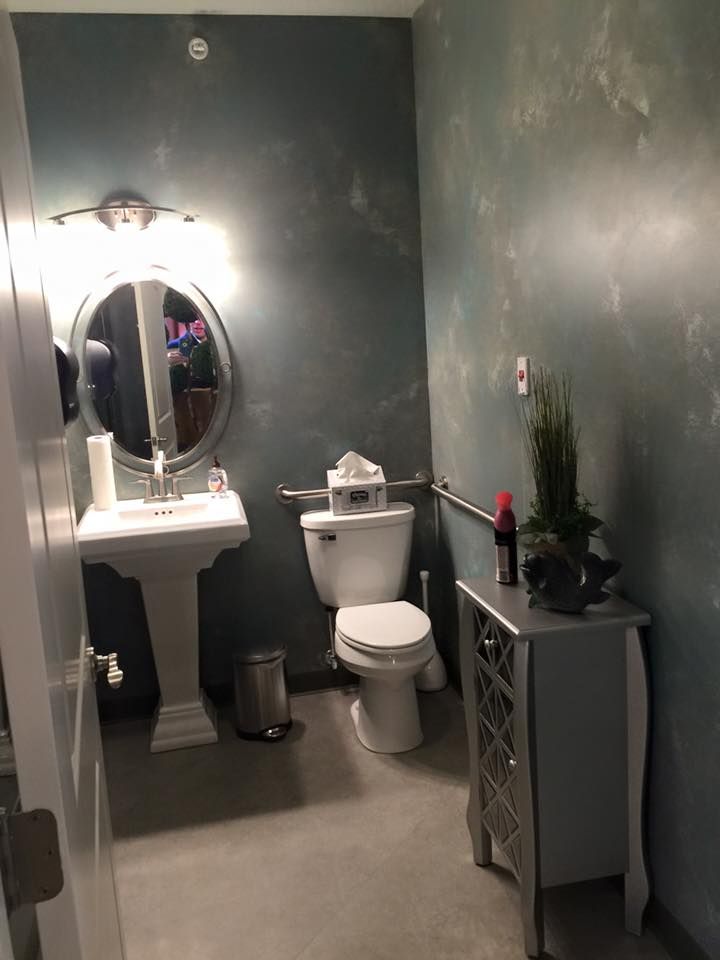 A modern bathroom with a pedestal sink and stylish decor.