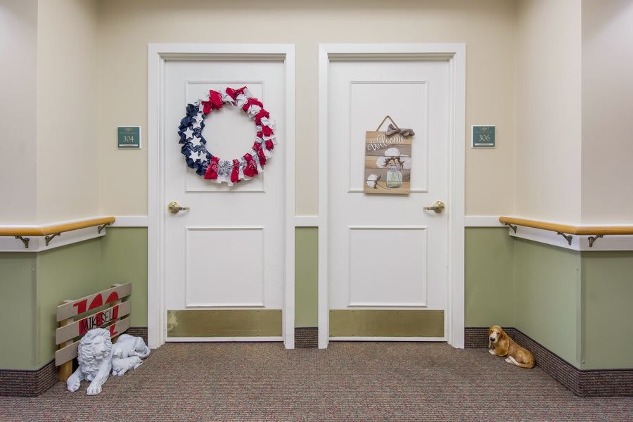 Decorated doors in a hallway with festive wreaths and signs.