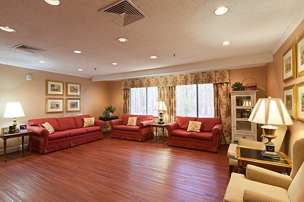 A cozy living room with red sofas and warm lighting.