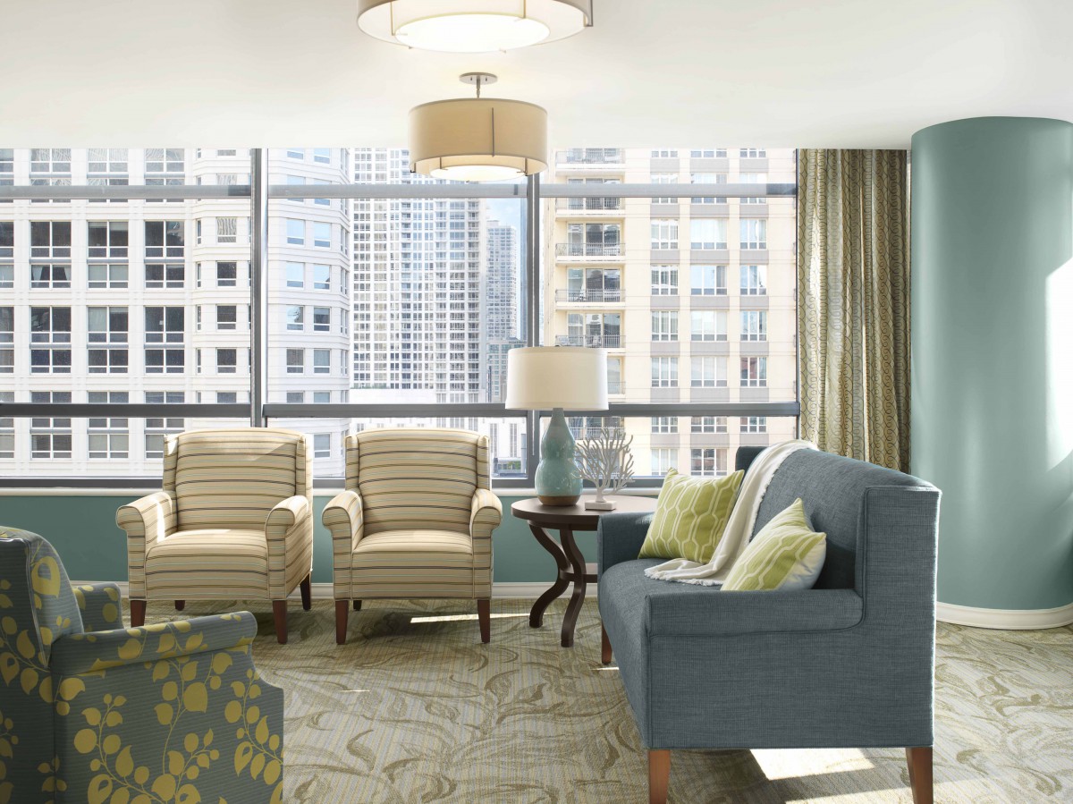 A modern living room with a city view, featuring comfortable seating and stylish decor.