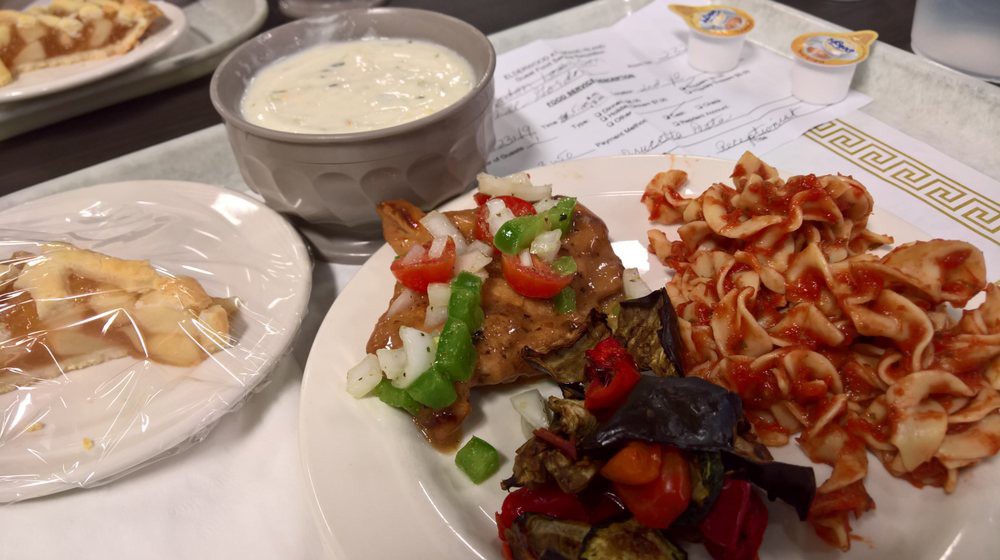 A delicious meal featuring a bowl of soup, pasta, and a variety of vegetables.