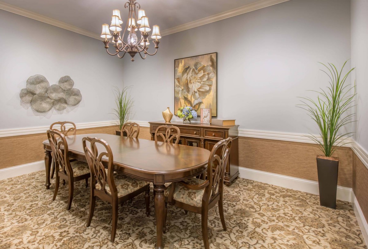 A traditional dining room featuring a wooden table set, ornate chairs, and a chandelier.