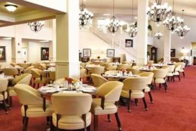 An elegant restaurant dining area with neatly arranged tables and chairs, adorned with chandeliers.
