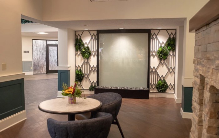 A modern lobby area with stylish furniture and decorative plants on the wall.