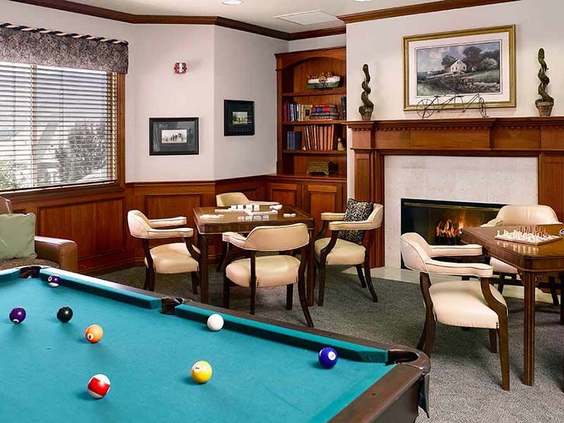 Cozy game room with a pool table, fireplace, and seating area.