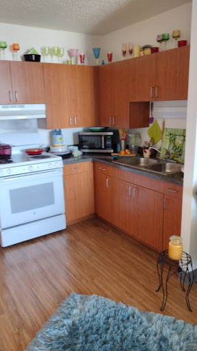 A cozy kitchen equipped with essential appliances and wooden cabinetry.