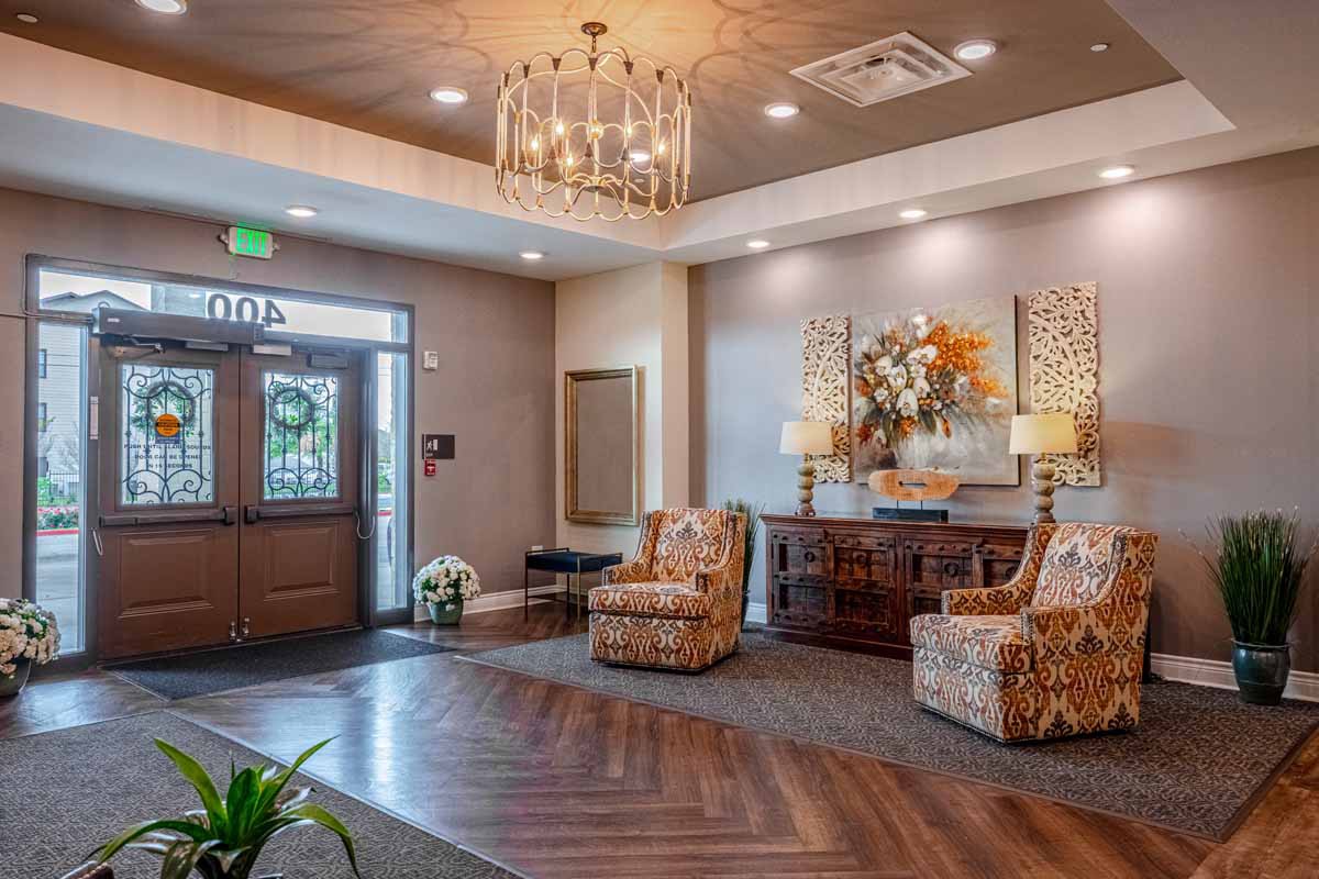 A cozy lobby with elegant decor, featuring a chandelier and comfortable seating.