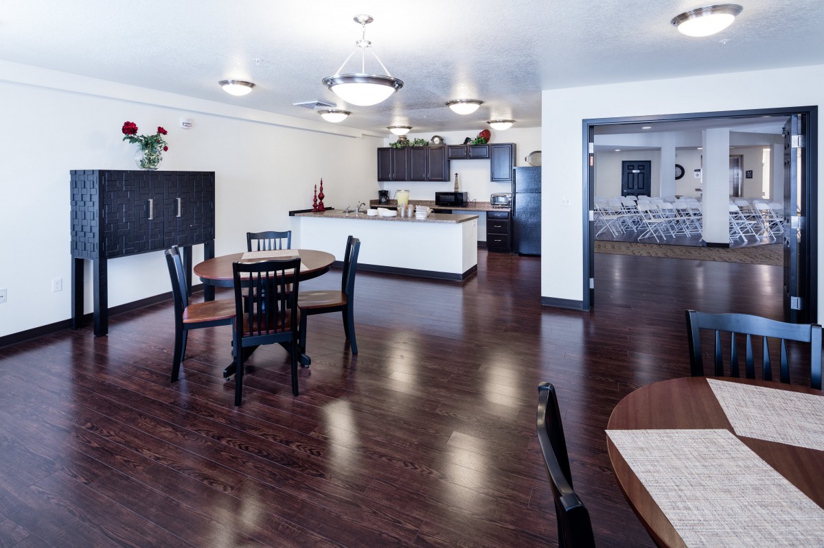 A modern kitchen and dining area with wood flooring and sleek cabinetry.
