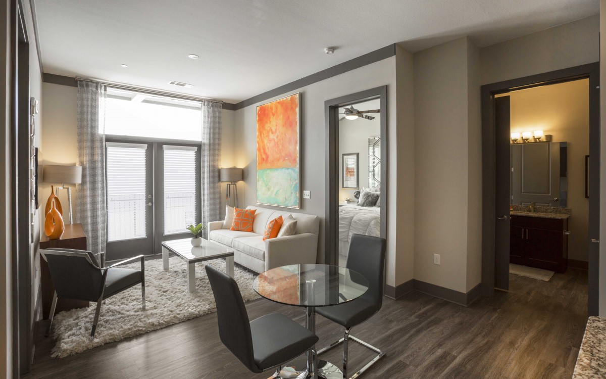 A modern and cozy living room in an apartment featuring stylish furniture and vibrant artwork.