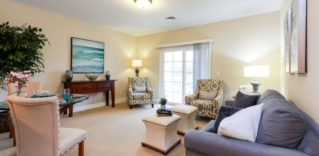 A cozy living room with comfortable seating and natural light streaming in from large windows.