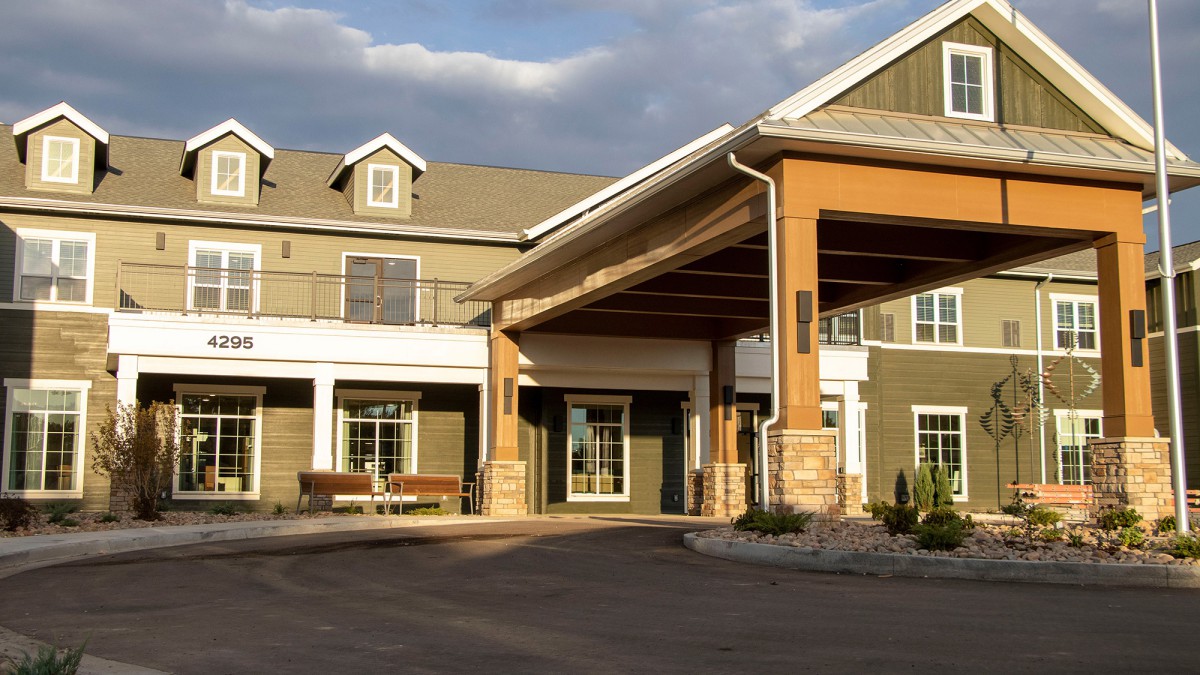 A sunny exterior view of a residential building entrance.