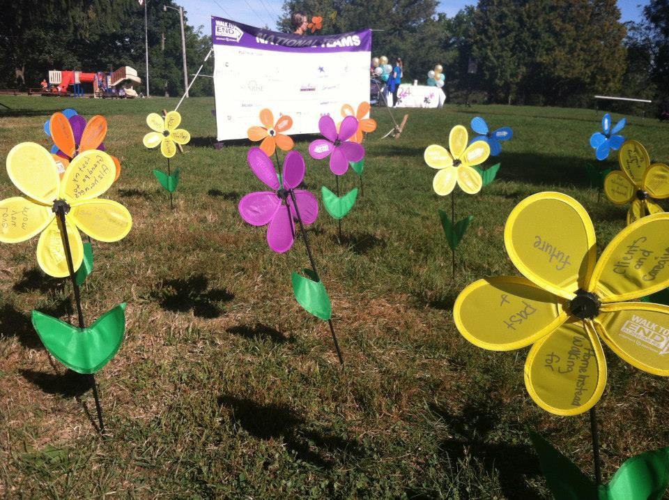 Colorful artificial flowers displayed at an outdoor event under sunny skies.