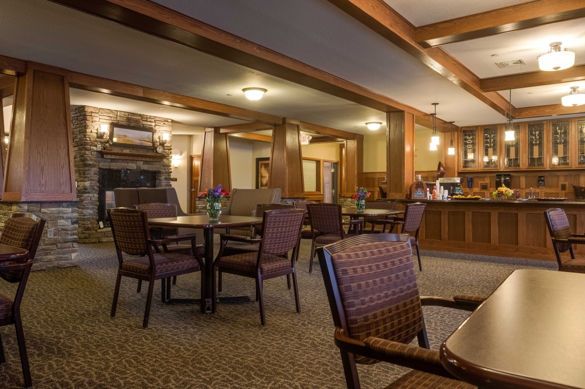 A cozy restaurant interior featuring wooden decor and neatly arranged dining tables.