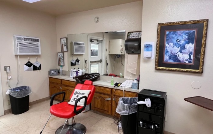 A cozy barbershop interior featuring a red chair and various hair styling tools.