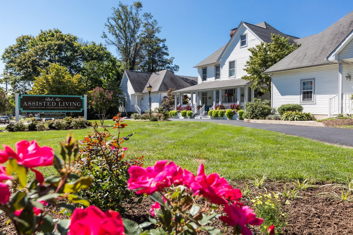 A charming house with a beautiful garden and vibrant flowers on a sunny day.