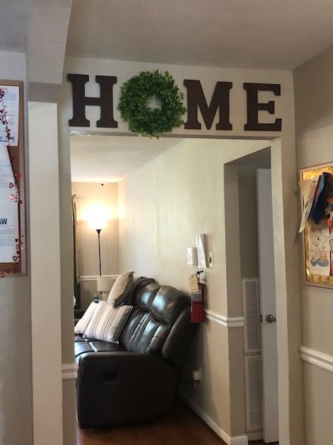 A cozy living room entrance with 'HOME' decor and a comfortable couch.